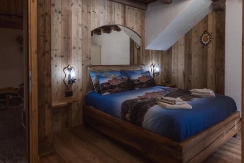 a bedroom with a large bed in a room with wooden walls at ALLE ANTICHE MINIERE - CASA VACANZE in Zenich