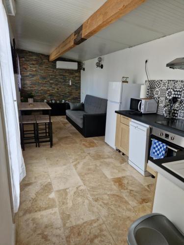 une cuisine et un salon avec un canapé et une table dans l'établissement Casita blanca, à Arles
