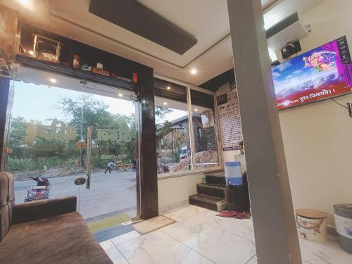 a front door of a restaurant with a tv on the wall at Hotel Shreem in Ujjain