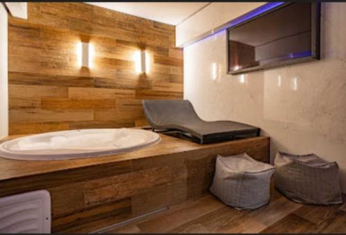 Motel Desireé في ساو باولو: حمام مع حوض أبيض كبير وكرسي