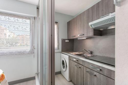 une cuisine avec un évier et une machine à laver dans l'établissement Location de vacances, au Cap d'Agde