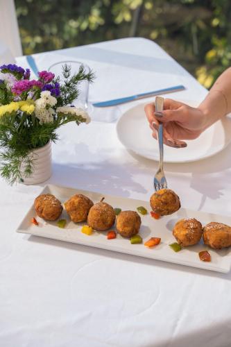a plate of meatballs on a table with a person holding a fork at MelRose Relais in Massa Lubrense