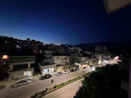 une ville la nuit avec des voitures garées dans un parking dans l'établissement Nick Apartments, à Gjirokastër