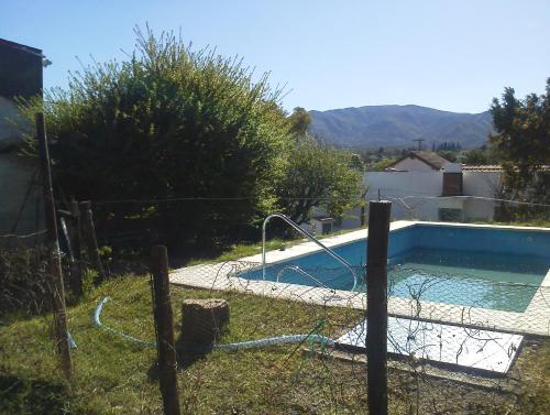 a swimming pool in a yard with a fence at La Casa de Ramatis in Valle Hermoso