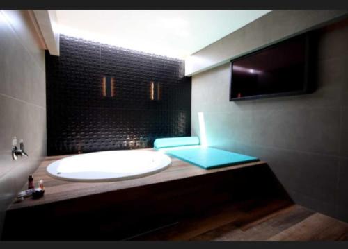 a bathroom with a white tub and a sink at Motel Desireé in Sao Paulo