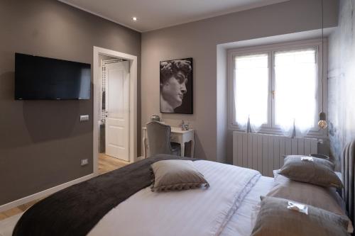 a bedroom with a large bed with a television on the wall at Ma Maison in Pian Nava