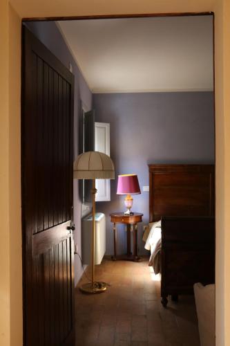 a room with a bedroom with a bed and a lamp at BORGO GIUSTINIANI Mora Pero Melo in San Martino di Venezze