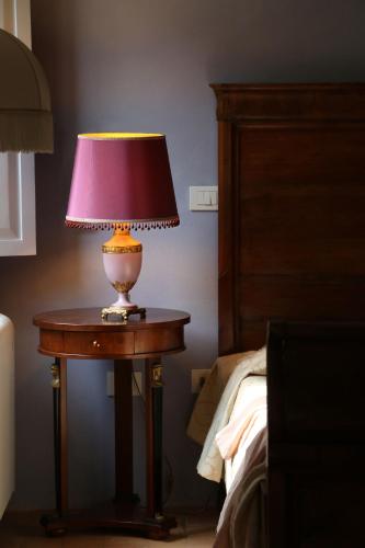 a lamp sitting on a table next to a bed at BORGO GIUSTINIANI Mora Pero Melo in San Martino di Venezze
