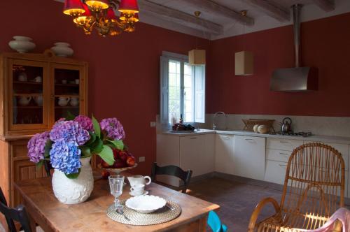 a kitchen with a table with a vase of flowers on it at BORGO GIUSTINIANI Mora Pero Melo in San Martino di Venezze