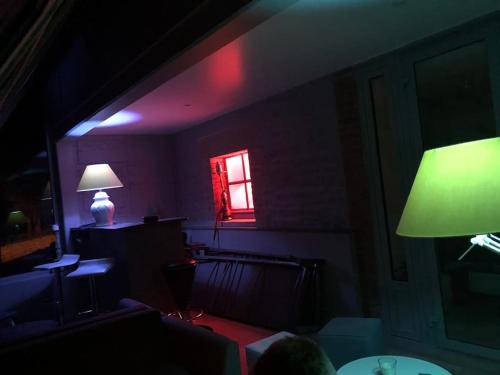 un salon avec une lampe verte et une fenêtre dans l'établissement VILLA CAROLLES, à Carolles