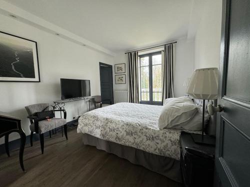 une chambre avec un lit, une télévision et une fenêtre dans l'établissement VILLA CAROLLES, à Carolles