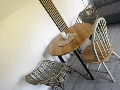 a wooden table with two chairs and a cup on it at Pokoje Gościnne Malinówka in Krościenko