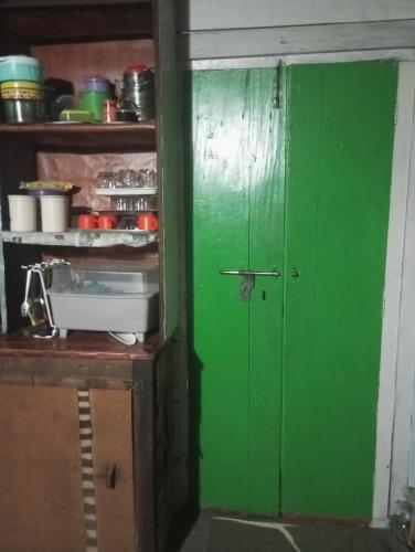 にあるAkhaluの棚付きキッチンの緑の扉