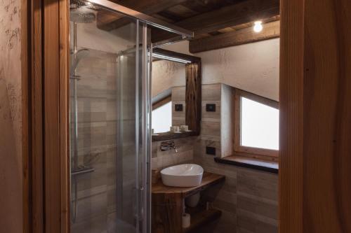 a bathroom with a sink and a glass shower at ALLE ANTICHE MINIERE - CASA VACANZE in Zenich