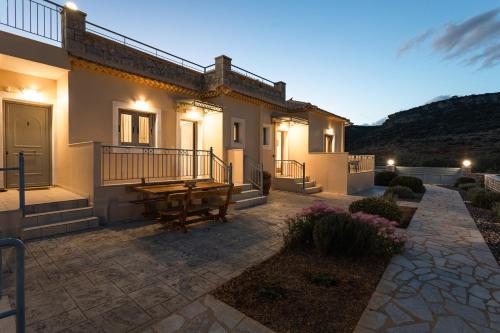 a house with a wooden table on a patio at Sundy Maria Apartments in Stoupa
