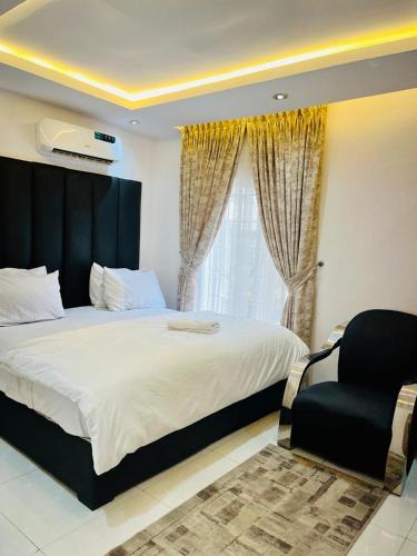 a bedroom with a bed and a chair and a window at Abefe Realtor in Lekki