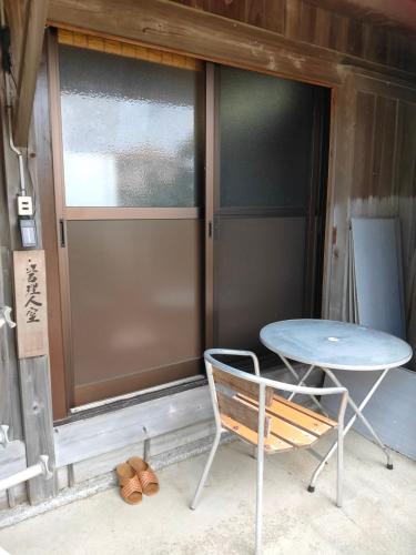 a table and a chair in front of a door at 玉の浦sea in Nachikatsuura