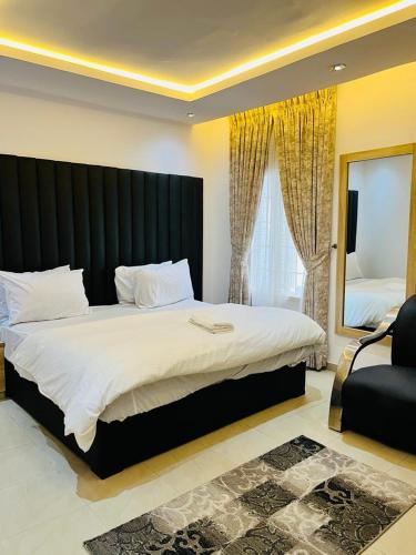 a bedroom with a large bed with a black headboard at Diaggello Homex Apartment in Lekki