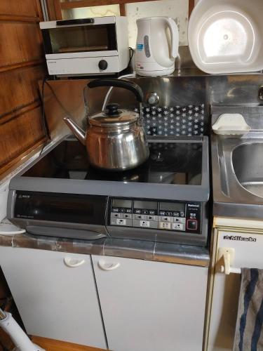 a tea pot sitting on top of a stove in a kitchen at 玉の浦sea in Nachikatsuura