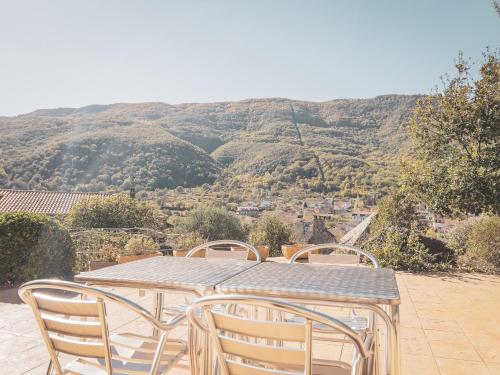 a table and chairs with a view of a mountain at Aiguabella - Allotjaments Rurals in Sant Felíu de Pallarols