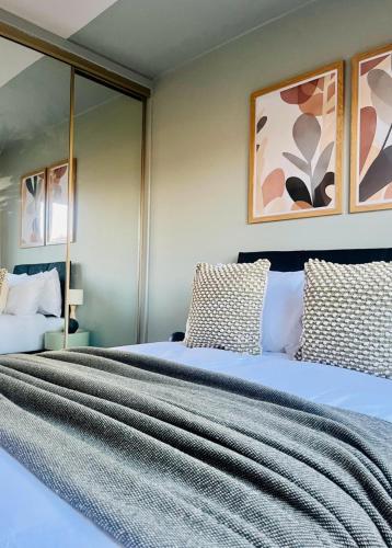 a bedroom with two beds and mirrors at Castle Gait Apartment in Paisley