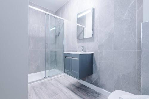 a bathroom with a blue sink and a shower at Southport Suites apartment 8 in Southport