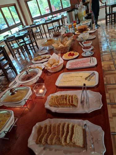 a long table with many plates of food on it at Villaflor Pousada in Vale do Capao