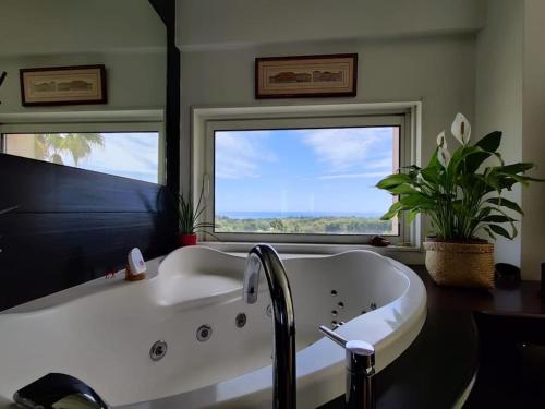 La salle de bains est pourvue d'une baignoire et de 2 fenêtres. dans l'établissement Villa Azur - Sea View, à Villeneuve-Loubet