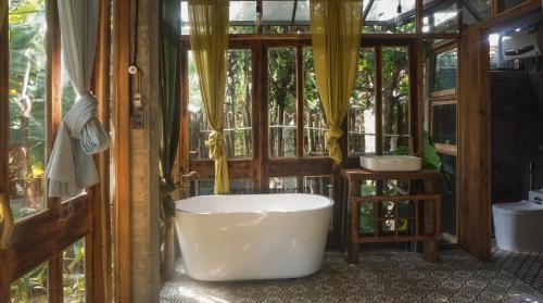 uma banheira na casa de banho com uma janela em Moon Garden Riverside em Thôn Kim Long (1)