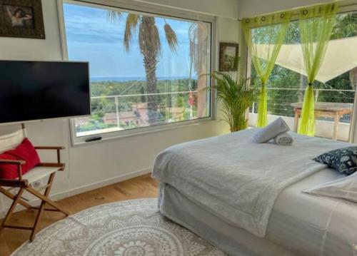 une chambre avec un lit et une grande fenêtre dans l'établissement Villa Azur - Sea View, à Villeneuve-Loubet