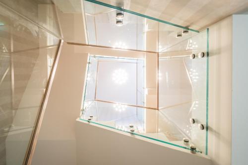 a glass shower with a window in a bathroom at Rabie Aparthotel in Prague
