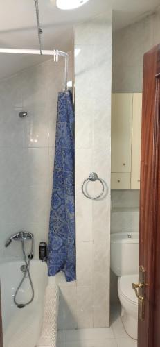 La salle de bains est pourvue de toilettes et d'un rideau de douche bleu. dans l'établissement Covelobeach, à Pontevedra