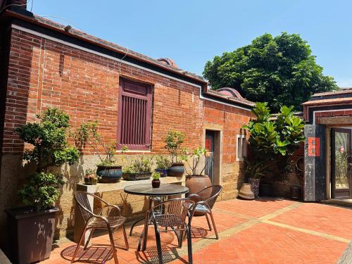 a patio with a table and chairs in front of a brick building at 心琴古厝包棟民宿 in Jinning