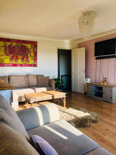 a living room with a couch and a table at ConnectU Apartment in Luton