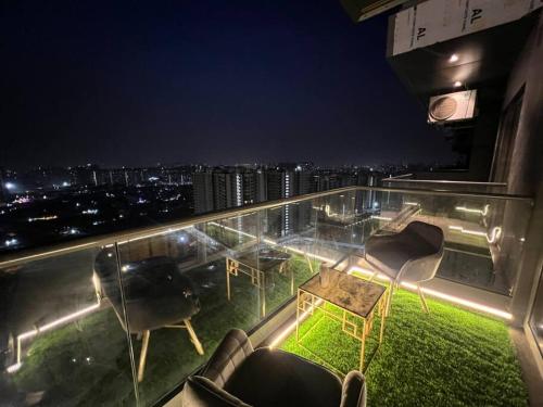 a balcony with chairs and tables on a building at night at The Silver Clouds 17th Floor Studio Apartment in Ghaziabad