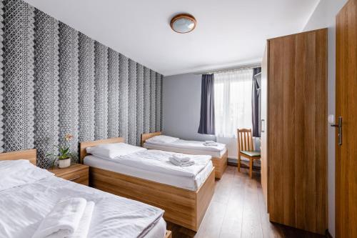 a hotel room with two beds and a chair at Sleep&Go in Lubliniec