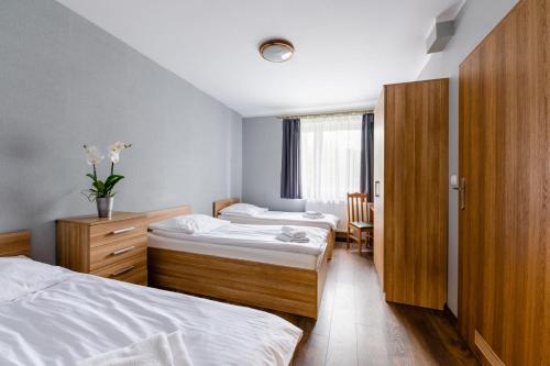 a bedroom with two beds and a table and chairs at Sleep&Go in Lubliniec