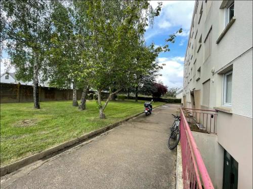 een motorfiets geparkeerd op een straat naast een gebouw bij Apparemment Rennes in Saint-Jacques-de-la-Lande