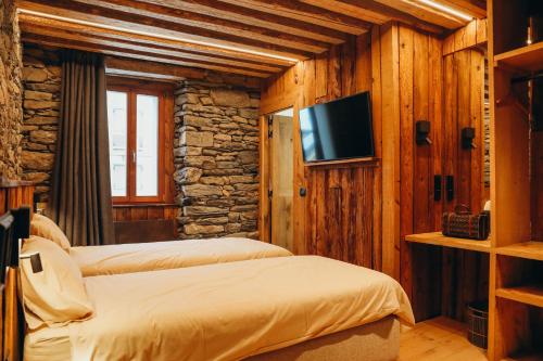 una camera con due letti e una televisione in una cabina di Le Château by Lodji a Saint-Marcel