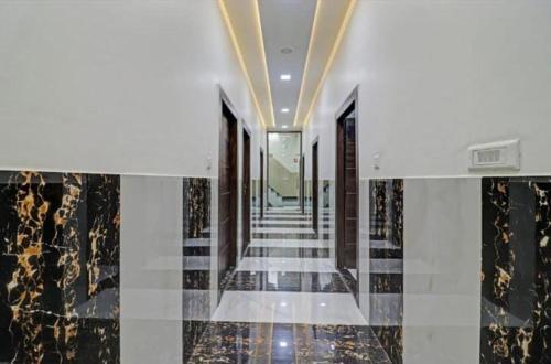 un pasillo con suelos y techos de mármol blanco y negro en hotel chahat palace, en Agra