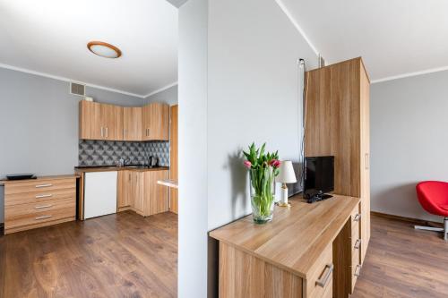 a kitchen with a desk with a vase of flowers at Sleep&Go in Lubliniec