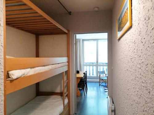 Cette chambre dispose de lits superposés, d'une table et d'une fenêtre. dans l'établissement LaGodille Pra Loup 1500, à Pra-Loup