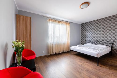 a bedroom with a bed and a red chair at Sleep&Go in Lubliniec