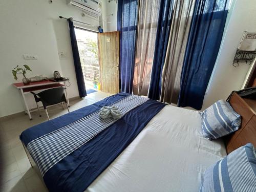 1 dormitorio con 1 cama grande y ventana en Home UbEx en Rishīkesh