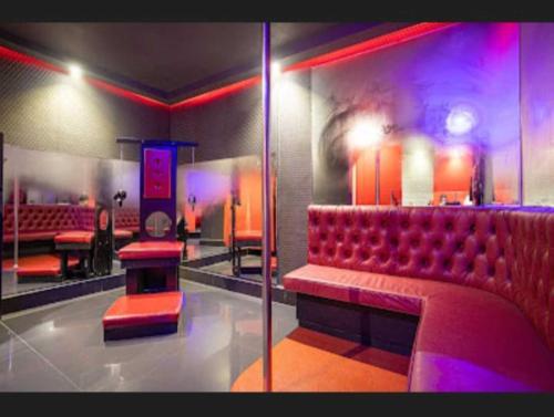 a room with a red bench and a bar at Motel Desireé in Sao Paulo