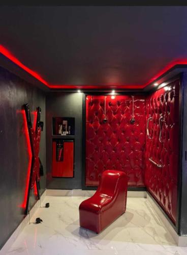 a red chair in a room with a red wall at Motel Desireé in Sao Paulo