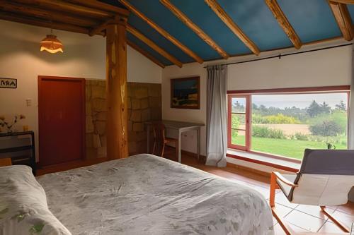 Casa de Campo con vista al mar في Chanco: غرفة نوم بها سرير ومكتب ونافذة