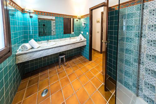 a bathroom with blue tiled walls and a sink at Hotel-Restaurante Casa García Almonaster La Real in Almonaster la Real