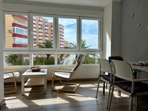トロクスにあるApartamento al lado del paseo marítimo Torrox Costaの椅子とテーブル、窓が備わる客室です。