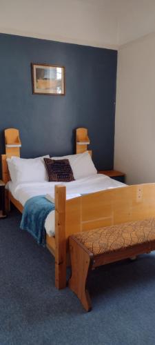 1 dormitorio con 2 camas y un banco en Kington Accommodation en Kington